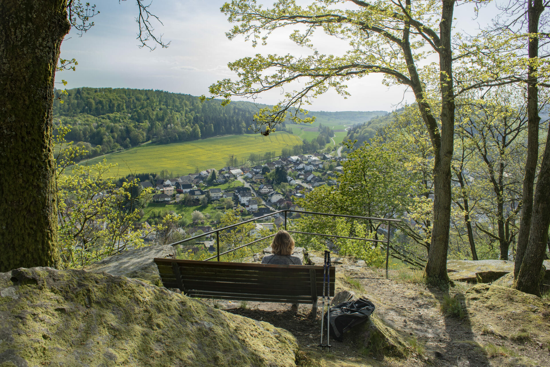Wanderin auf einer Bank mit Blick auf den MIttelberg