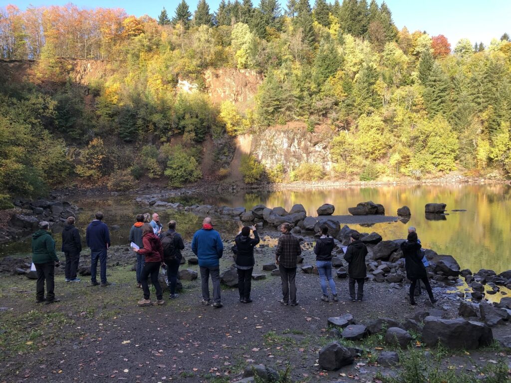 Gruppe von Menschen stehen vor dem Katzenbuckelsee im Herbst