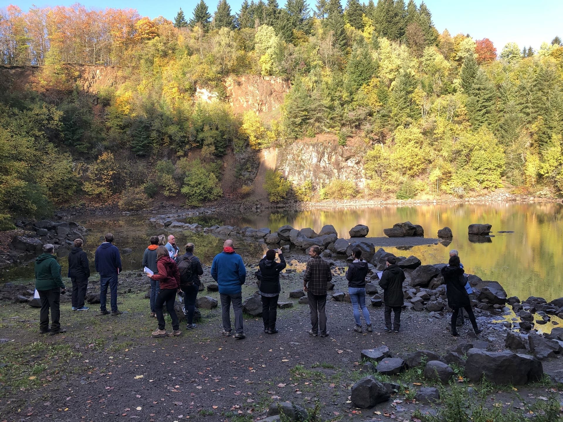 Gruppe von Menschen stehen vor dem Katzenbuckelsee im Herbst