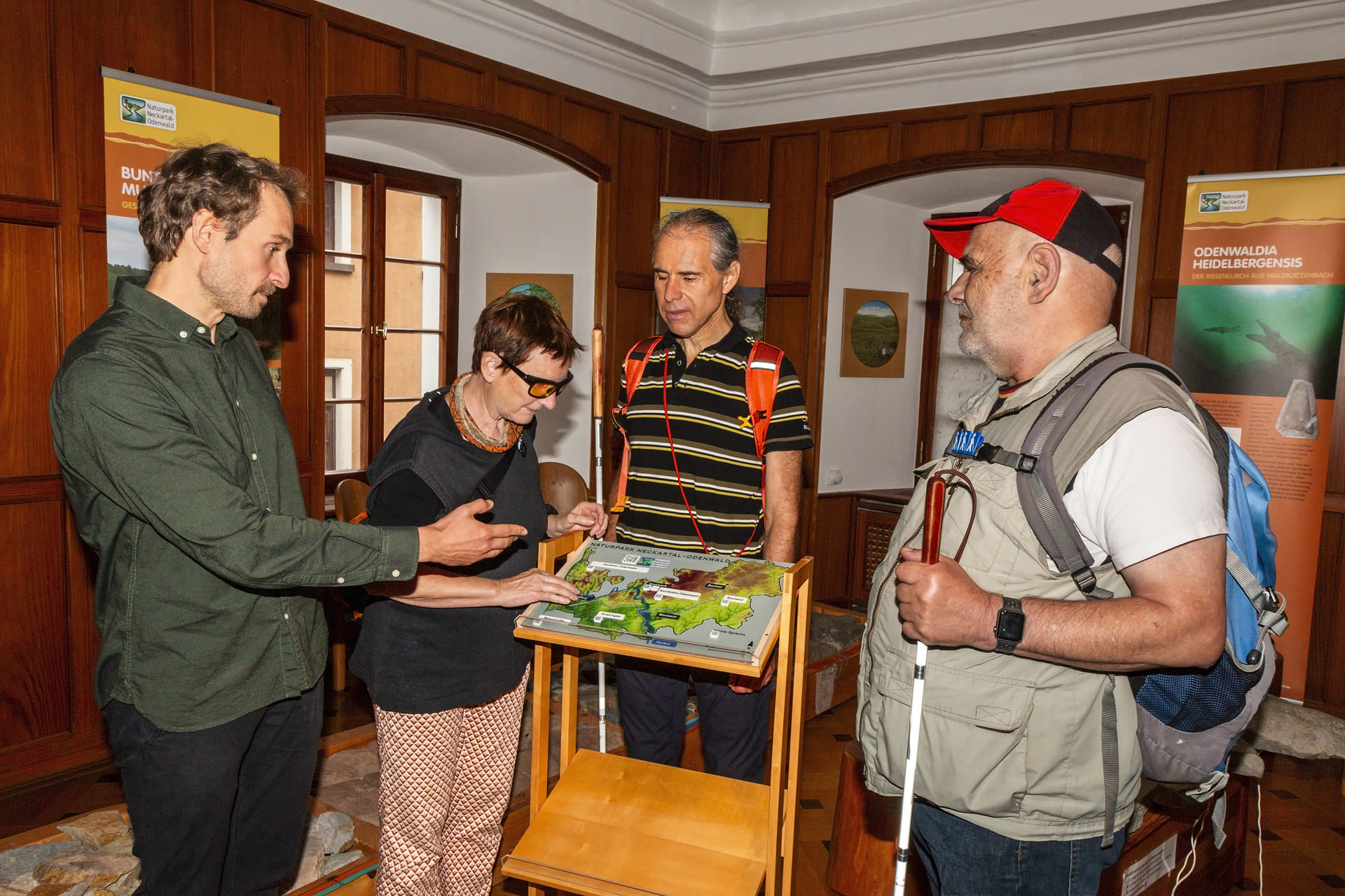 Gruppe von Menschen steht um die taktile Karte herum und testet sie